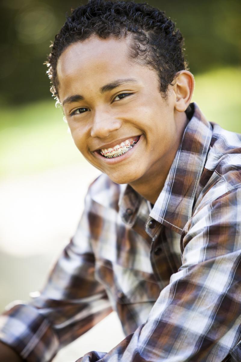 Junge mit fester Zahnspange in Natur