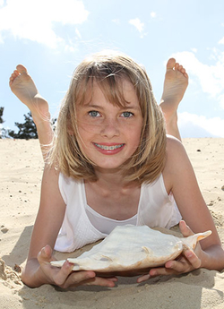 Mädchen mit Zahnspange am Strand